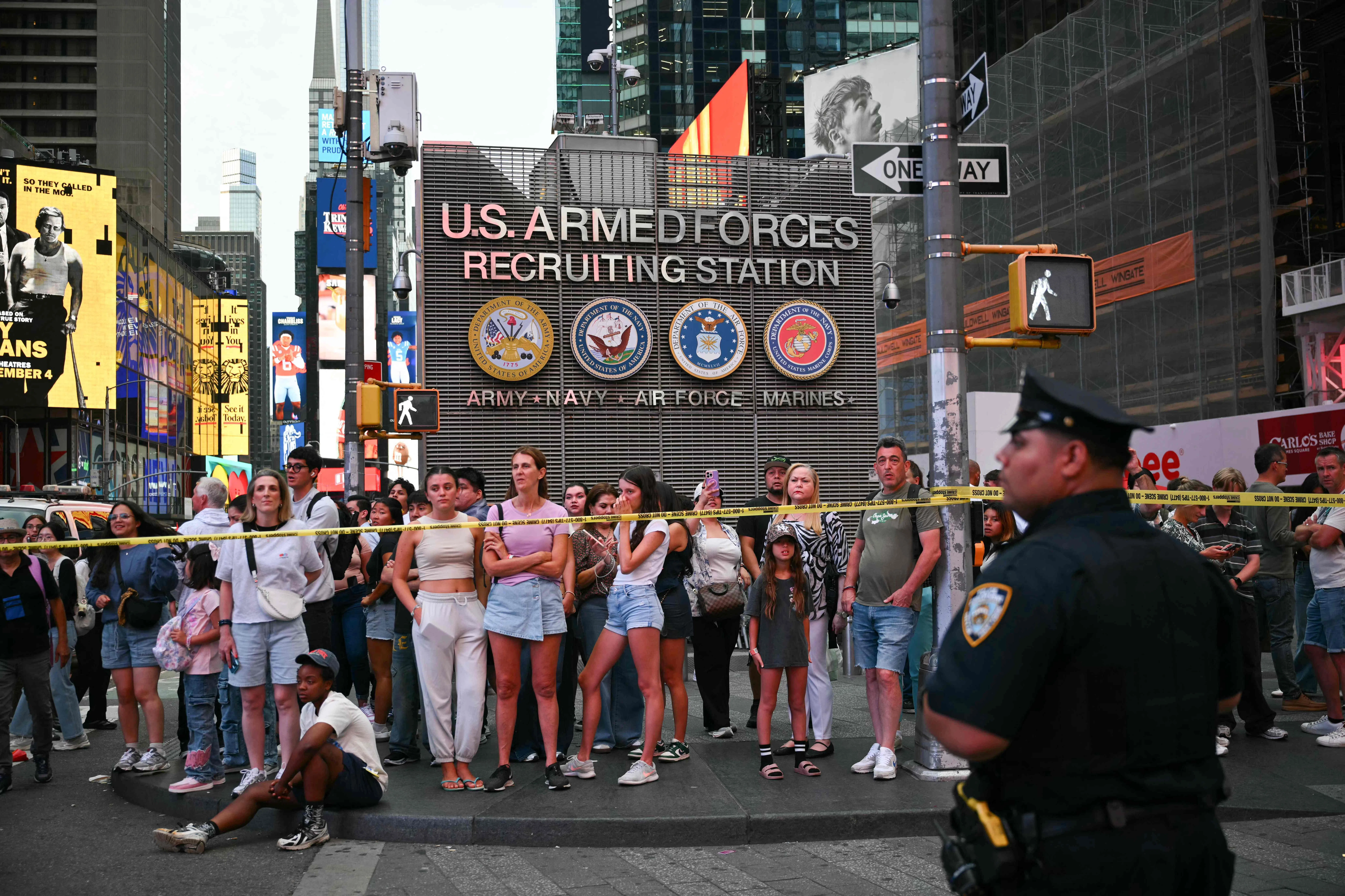 People observe the scene where an officer-involved shooting left one dead near Times Square, in New York, on August 31, 2026. According to ABC7 New York, a woman stabbed two people before confronting police. (Photo by ANGELA WEISS / AFP)