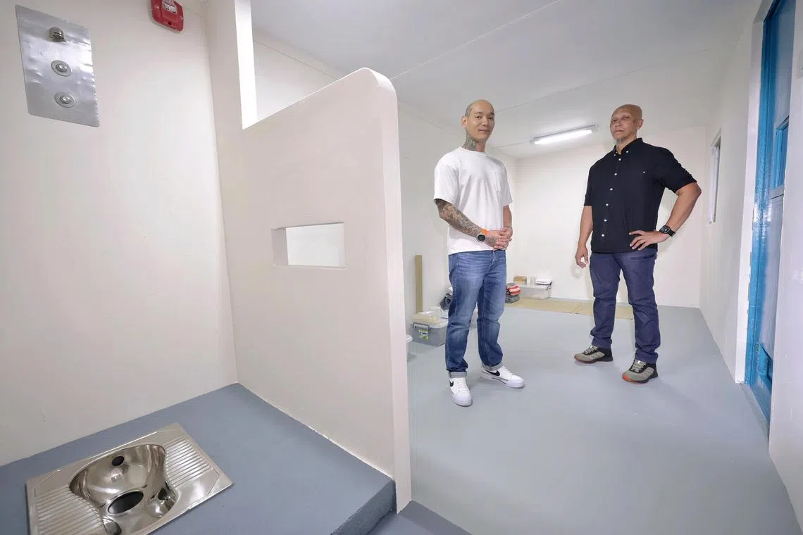 Ex-offender and fitness professional Andyn Kadir (left), 40, and Ustaz Mohamed Basir Mohamed Shariff, 58, programme director of MCS, posing for a photo in the mock prison cell at Mawar Community Services (MCS) Hub, which was established in 1978 to support former drug offenders and reduce their rate of re-offending, on Feb 1, 2025. ST PHOTO: KEVIN LIM wymcs01