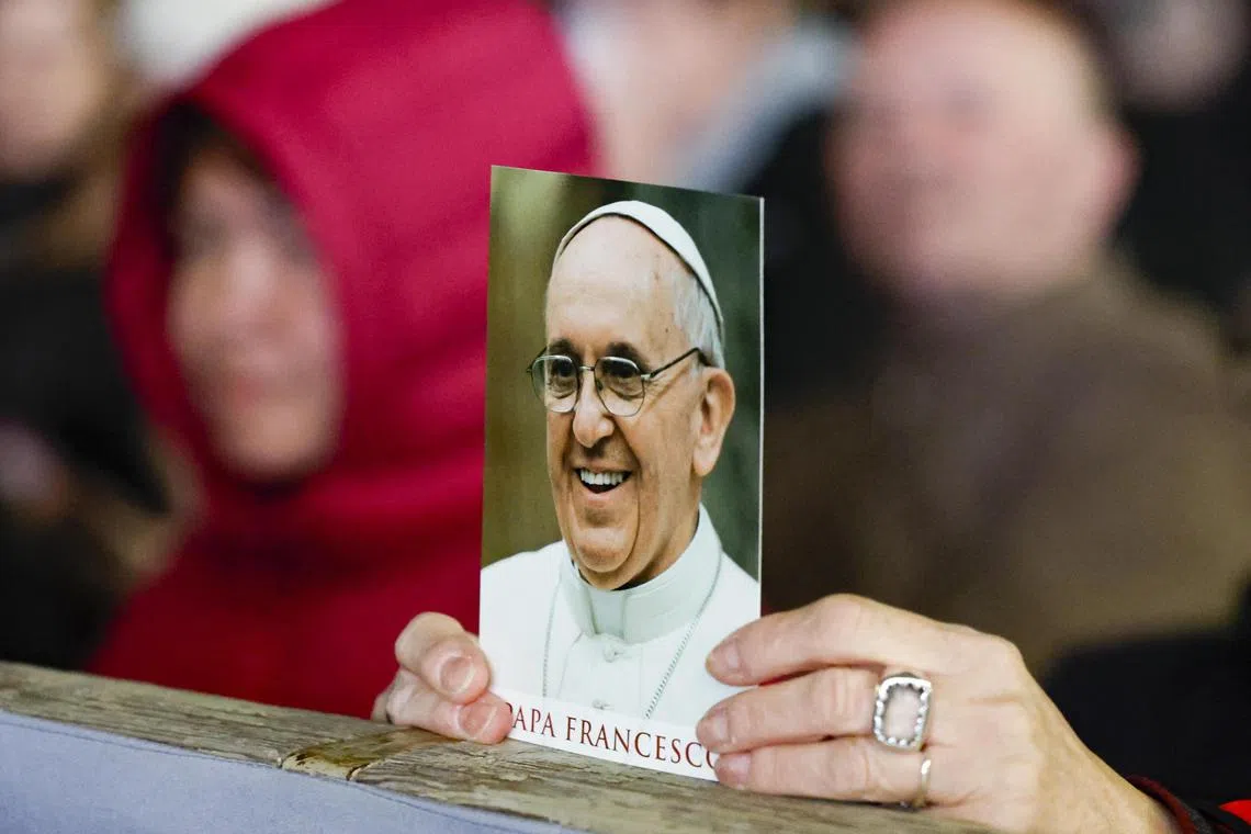 People praying on March 19 for the health of Pope Francis, who is hospitalised with pneumonia at Rome's Gemelli Hospital.