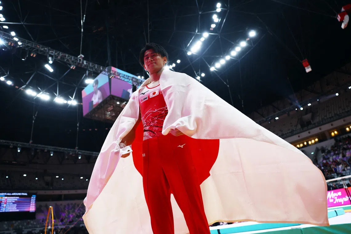 Artistic Gymnastics - 2025 World Artistic Gymnastics Championships - Mens Artistic Gymnastics - All-Around Final - Indonesia Arena, Jakarta, Indonesia - October 22, 2025 Japan's Daiki Hashimoto celebrates with the Japan flag after winning the All-Around Final REUTERS/Issei Kato