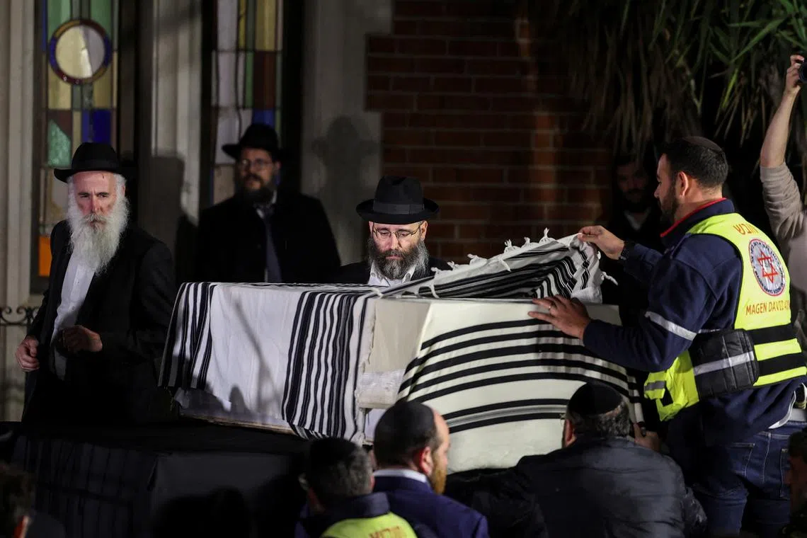 People stand next to the coffin of Israeli rabbi, Zvi Kogan, who was found murdered in the United Arab Emirates, during his funeral, in Kfar Habad, Israel, November 25, 2024. REUTERS/Stoyan Nenov