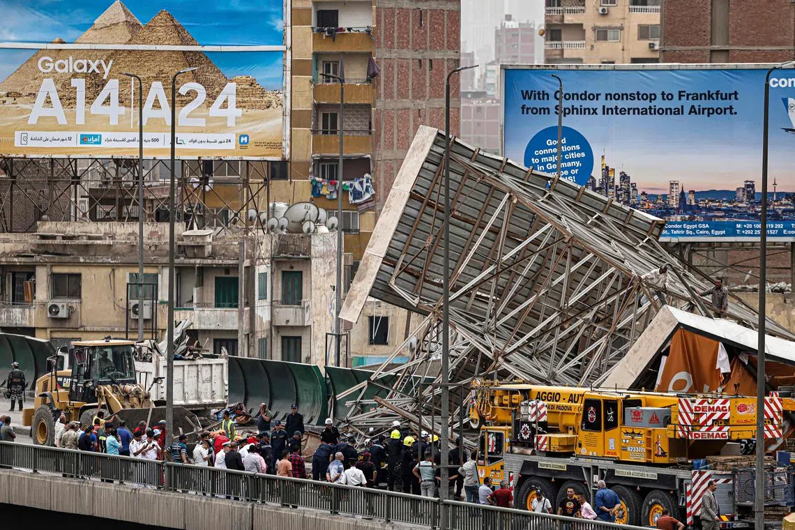 Police and civil defence gather as a collapsed billboard is removed from a bridge in central Cairo.