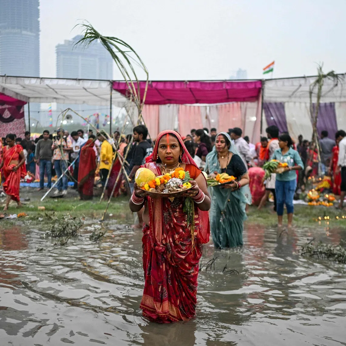 Hindu devotees offering prayers to the sun god Surya in the Yamuna river in New Delhi on Oct 27.