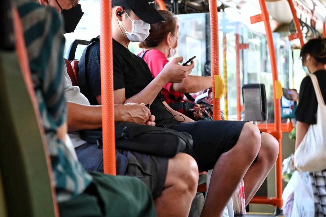 Generic pix of people on their mobile phones while travelling on a public bus in Bishan on 28 Dec 2021.