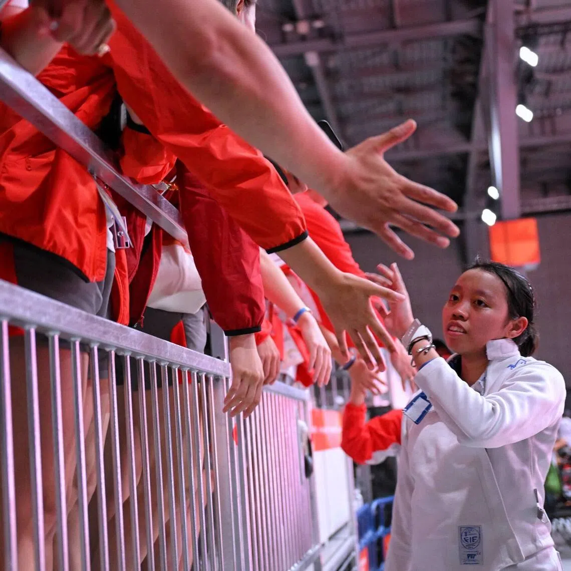 The Singapore fencing contingent high-fives Kiria Tikanah of Singapore after her Women’s Epee Individual final match against Song Se-ra of South Korea at the Aichi Sky Expo Hall on Sept 22.