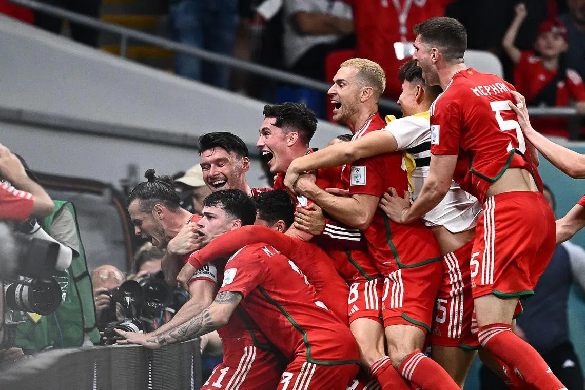Wales' forward Gareth Bale (left) celebrating with teammates after equalising against the United States during their World Cup Group B match on Monday (Nov 21).