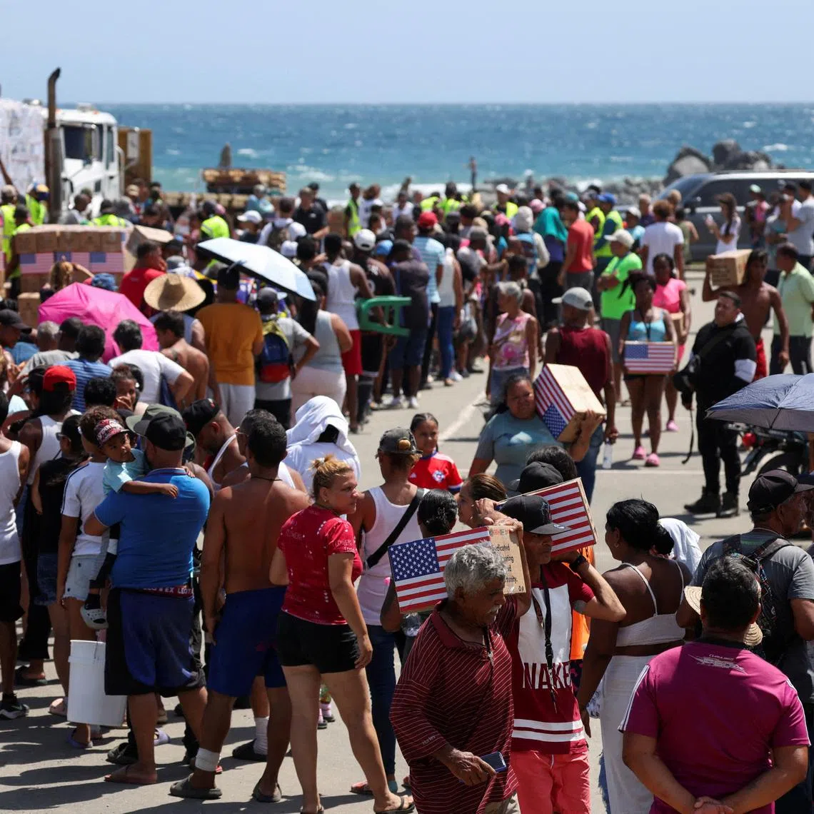 People affected by the disaster queue to receive humanitarian aid distributed by personnel from the US-based non-profit organization Global Empowerment Mission (GEM), in the aftermath of the June 24 earthquakes, in Catia la Mar, La Guaira state, Venezuela July 8, 2026. REUTERS/Leonardo Fernandez Viloria