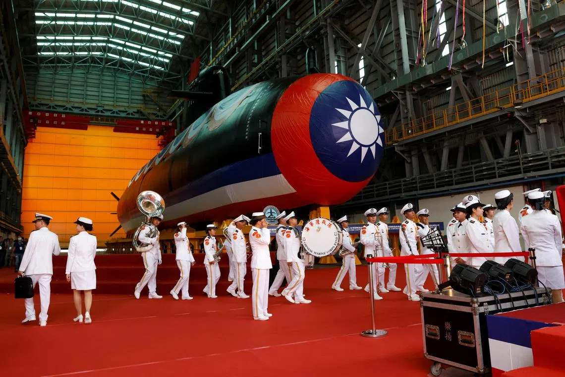 Members of the navy band walk past Haikun, Taiwan's first domestically built submarine, after its launch in Kaohsiung, Taiwan, on Sept 28.