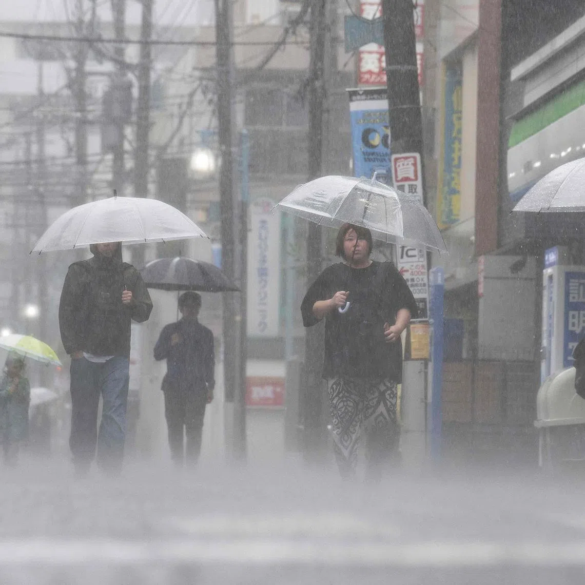 People commute in heavy rain brought by severe tropical storm Jangmi in Kawasaki, Kanagawa prefecture, on June 3.