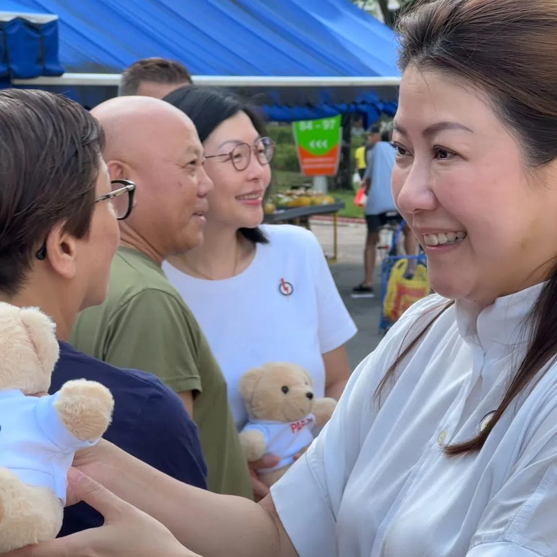 Wah & Hua CEO Melissa Tan (right) giving out PAP70 teddy bears at Bedok 85 Market with East Coast GRC MP Cheryl Chan (centre, in white) on Nov 17.