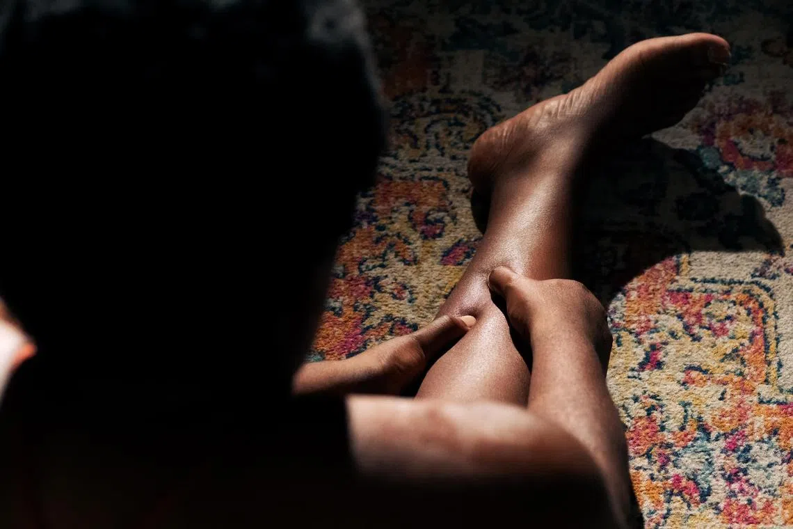 A woman massages her muscles at home in New York, Nov 7, 2023. Post-exercise stiffness is a part of any fitness regimen, but many treatments do not address the underlying cause. 