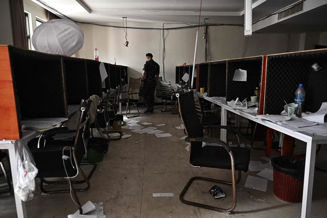 A Royal Thai Army officer looks at work booths inside an abandoned scam centre in O'Smach town on the Thai-Cambodian border.