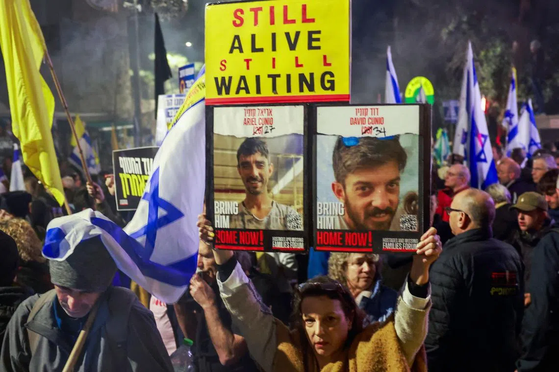 Relatives and supporters of Israelis held hostage in the Gaza Strip by Palestinian militants since October 2023, lift placards during a rally calling on the government for a deal that would bring all the remaining captives back.