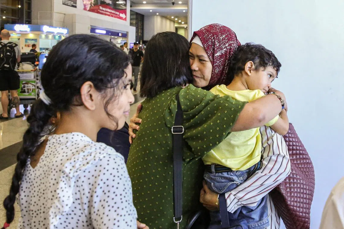 A Filipino national who crossed from the Gaza Strip into Egypt embraces her family members upon her arrival at Ninoy Aquino International Airport in Metro Manila on Nov 10, 2023. 