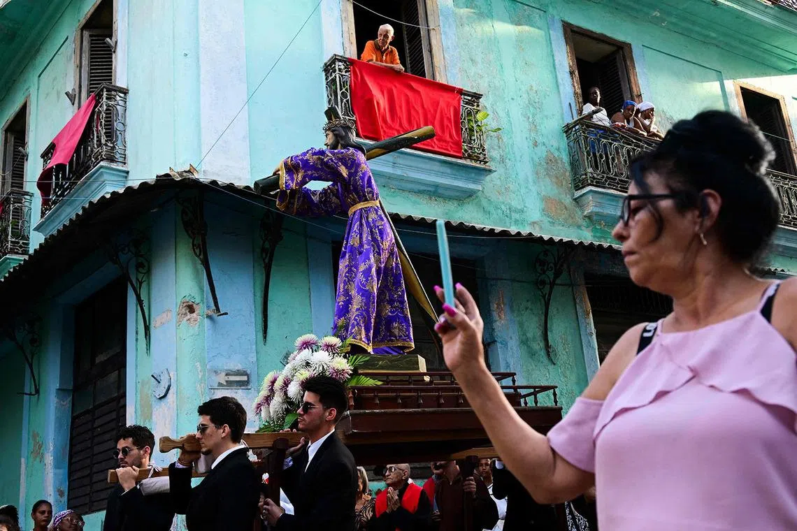 TOPSHOT - Catholic faithful take part in the Via Crucis (Way of the Cross) on Good Friday during Holy Week in Havana on April 3, 2026. (Photo by YAMIL LAGE / AFP)