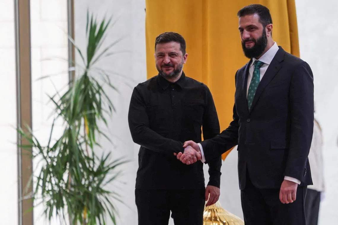 Ukraine's President Volodymyr Zelenskiy shakes hands with Syria's President Ahmed al-Sharaa as they meet in Damascus, Syria, April 5, 2026. REUTERS/Khalil Ashawi