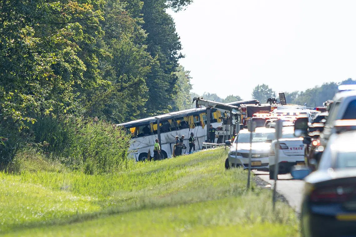 A tour bus, righted by a tow truck, after a rollover crash on the New York State Thruway in Pembroke, N.Y., about 30 miles east of Buffalo, N.Y, on Friday afternoon, Aug. 22, 2025. The tour bus traveling from Niagara Falls to New York City crashed on a highway outside Buffalo on Friday, killing multiple passengers, including at least one child, and leaving some people trapped beneath the vehicle, officials said. (Lauren Petracca/The New York Times)