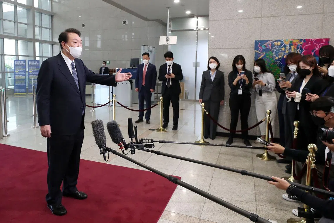 South Korea's President Yoon Suk-yeol (L) speaks to reporters as he arrives at the presidential office in Seoul on October 4, 2022. - South Korean President Yoon Suk-yeol vowed on October 4, that there would be a "stern response" to North Korea's latest sanctions-busting test of an intermediate range ballistic missile, which flew over Japan, prompting evacuations. (Photo by YONHAP / AFP) / - South Korea OUT / REPUBLIC OF KOREA OUT  NO ARCHIVES  RESTRICTED TO SUBSCRIPTION USE