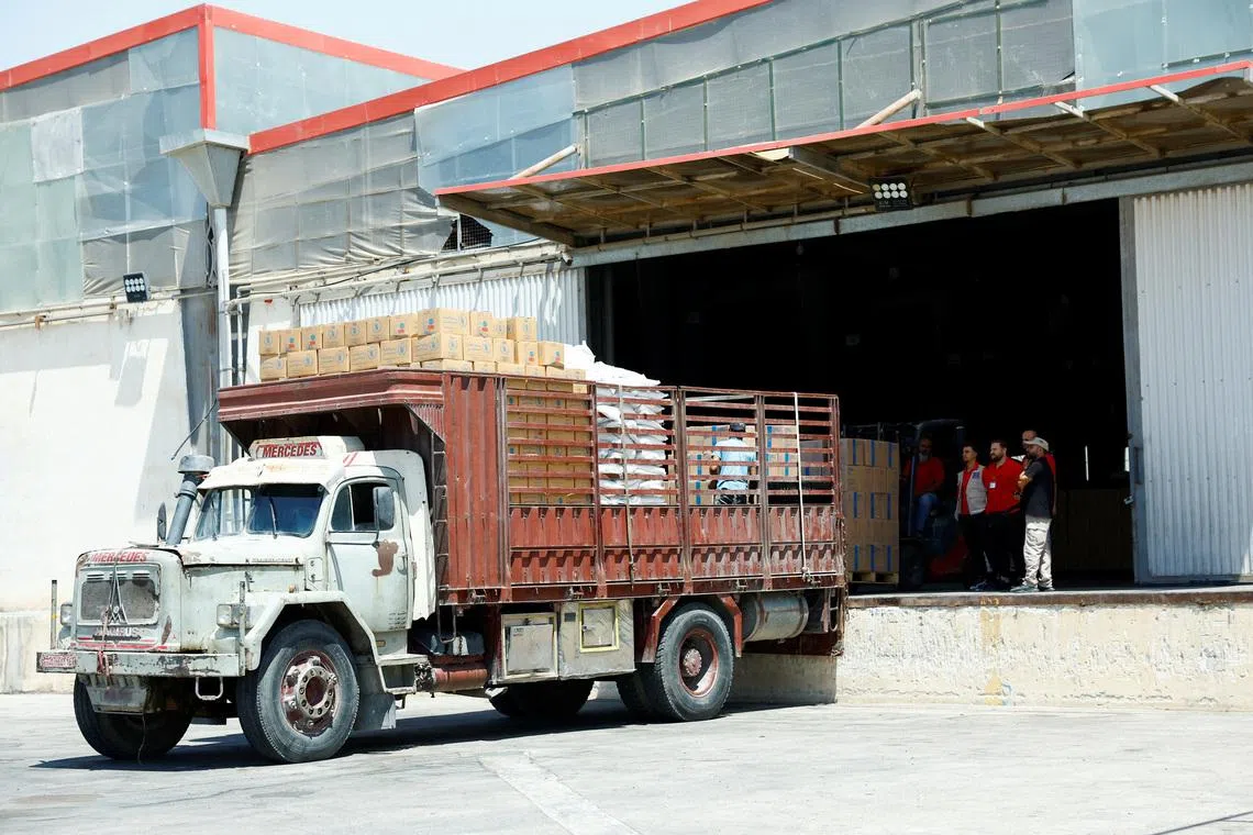 Workers load aid boxes onto a truck at a World Food Programme (WFP) facility in Damascus countryside, Syria, July 29, 2025. REUTERS/Yamam Alshaar