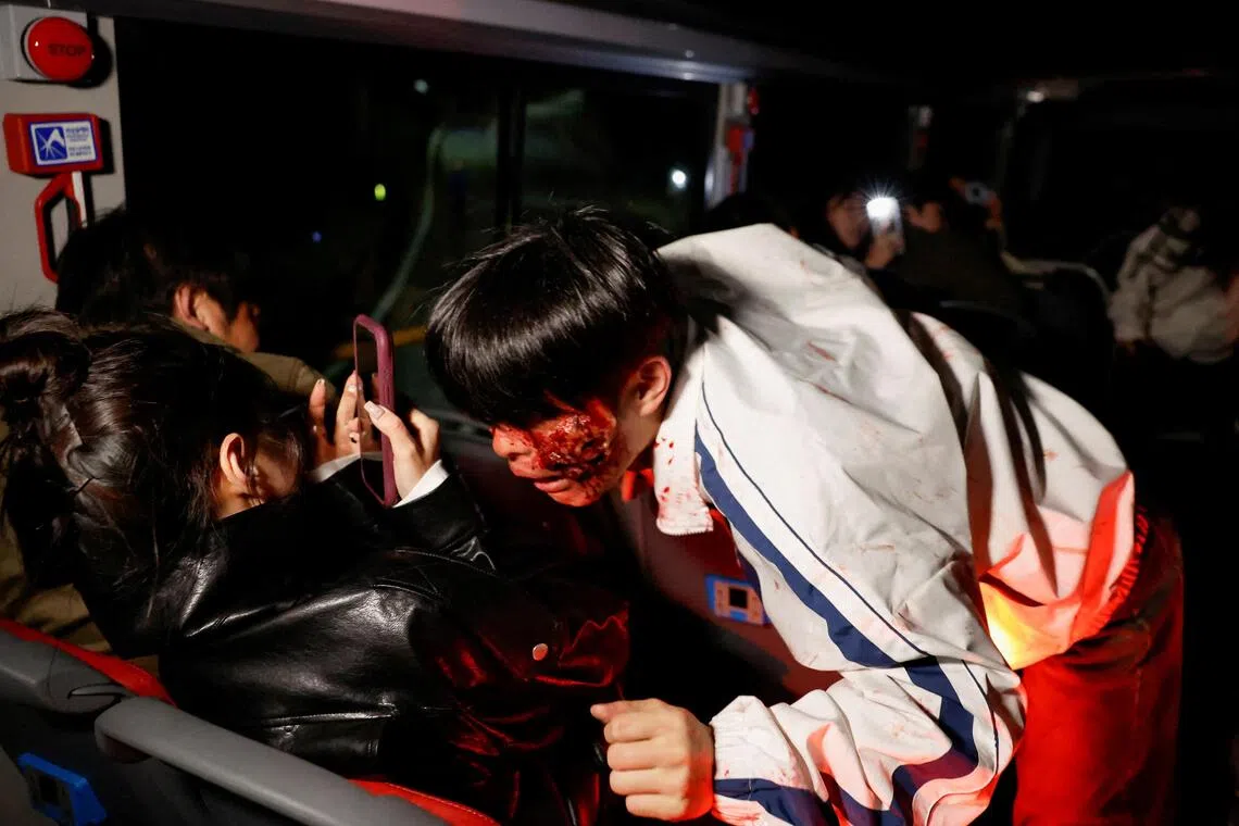 An actor dressed as a zombie leans towards a passenger aboard a bus during the Seoul City Tour Tiger Bus Zombie Attack event on Oct 21.