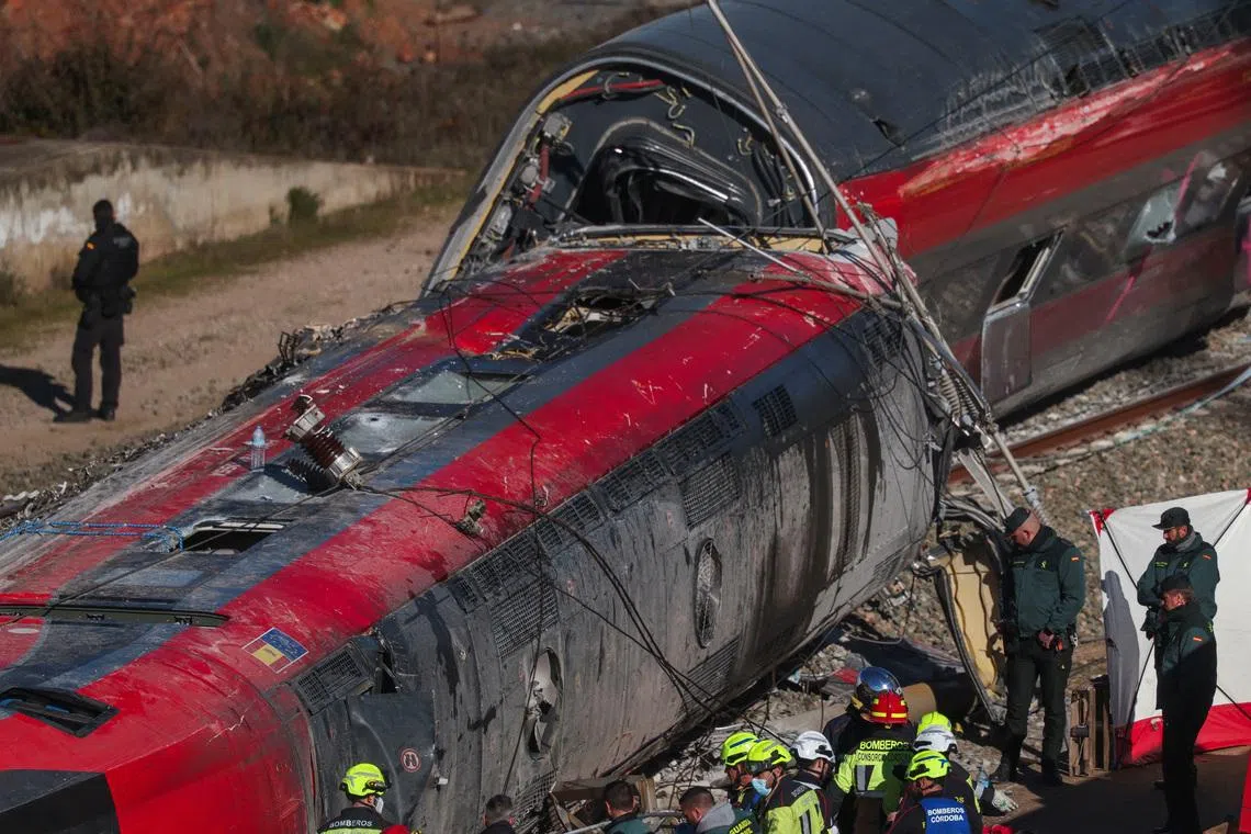 Members of the Spanish Civil Guard, along with other emergency personnel, work next to one of the trains involved in the accident, at the site of a deadly derailment of two high-speed trains near Adamuz, in Cordoba, Spain, January 19, 2026. REUTERS/Susana Vera