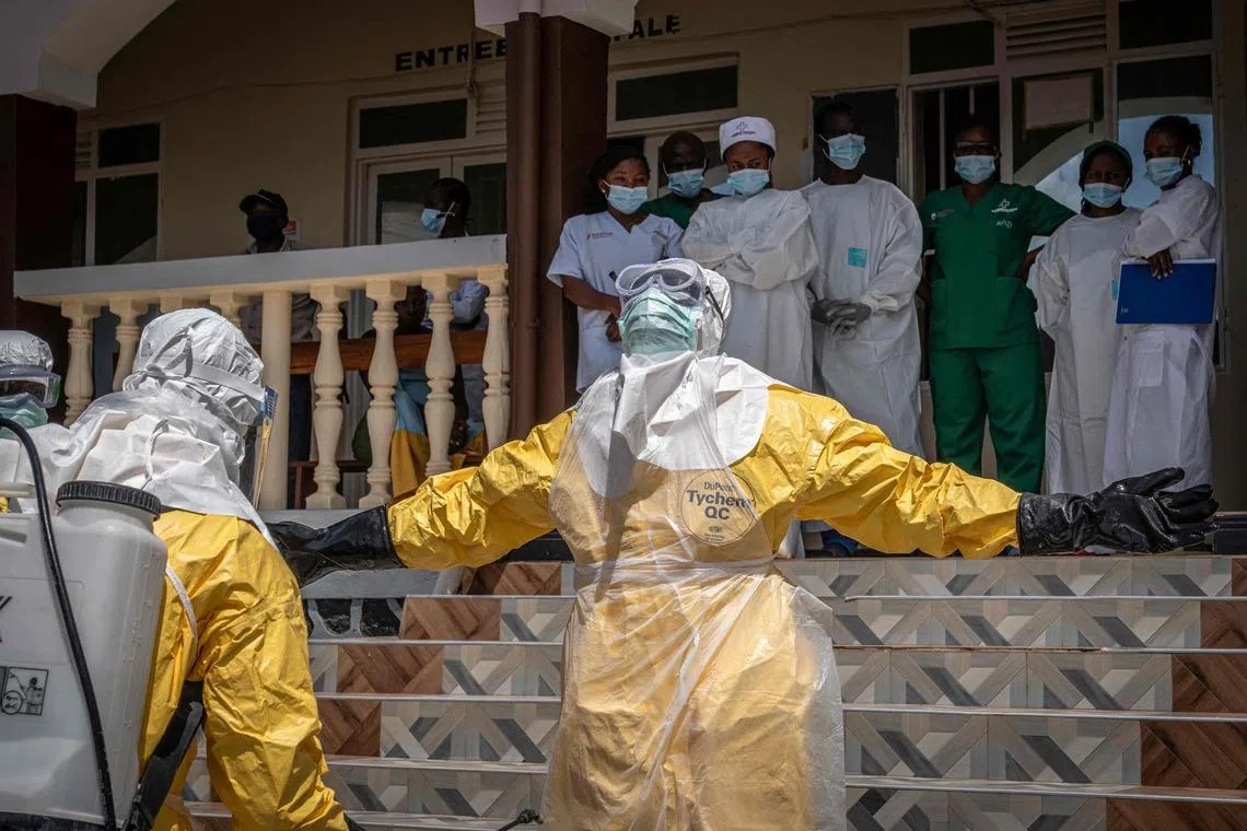 Health workers are sprayed with disinfectant after coming into contact with the body of a person suspected of having died from Ebola in Bunia, in the eastern Democratic Republic of the Congo, on May 25, 2026. 