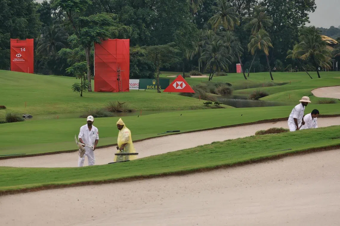 Workers shoveling sand from wet sections of the bunker on the Tanjong Course at Sentosa Golf Club after the Pro-Am event for 2023 HSBC Women’s World Championship was cancelled due to heavy overnight downpour on March 1, 2023.  