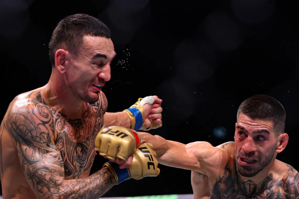 epa11685990 Ilia Topuria (Red) and Max Holloway (Blue) in action during their Featherweight bout at UFC 308 in Abu Dhabi, United Arab Emirates, 26 October 2024.  EPA-EFE/ALI HAIDER