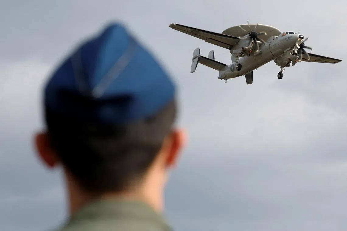 A member of the Taiwan Air Force looks on as an E-2K aircraft flies past during a demonstration for the media at the Pingtung air base in Pingtung, Taiwan January 30, 2024. REUTERS/Carlos Garcia Rawlins