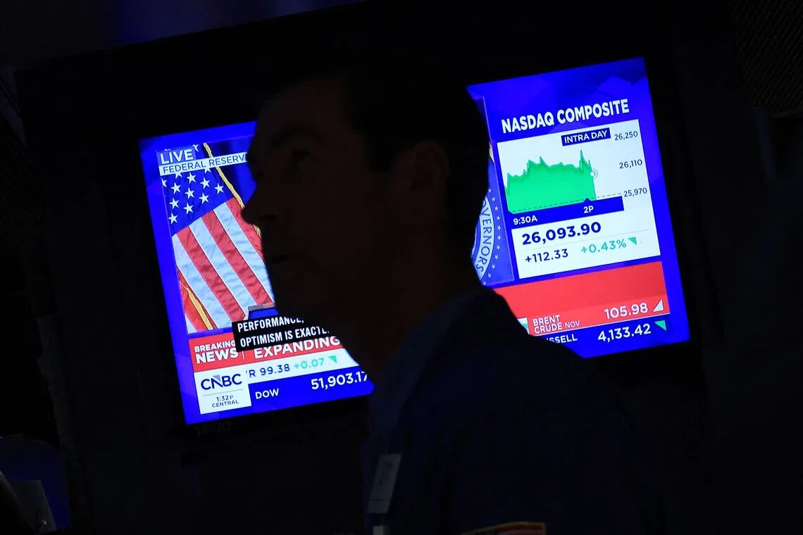 Traders work on the floor of the New York Stock Exchange as a screen broadcasts news on the US Federal Reserve’s interest rate hike in New York City, Sept 16.