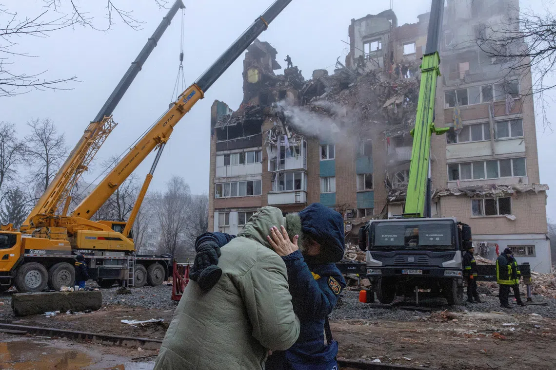 FILE PHOTO: A psychologist comforts a resident in front of an apartment building that was hit yesterday by a Russian missile, amid Russia's attack on Ukraine, in Ternopil, Ukraine, November 20, 2025. REUTERS/Thomas Peter             /File Photo
