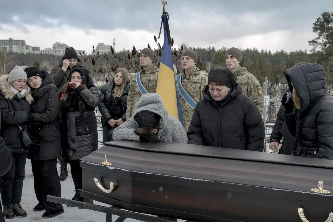 Mourners grieve for a Ukrainian soldier killed in fighting near the fiercely contested city of Bakhmut, in eastern Ukraine.