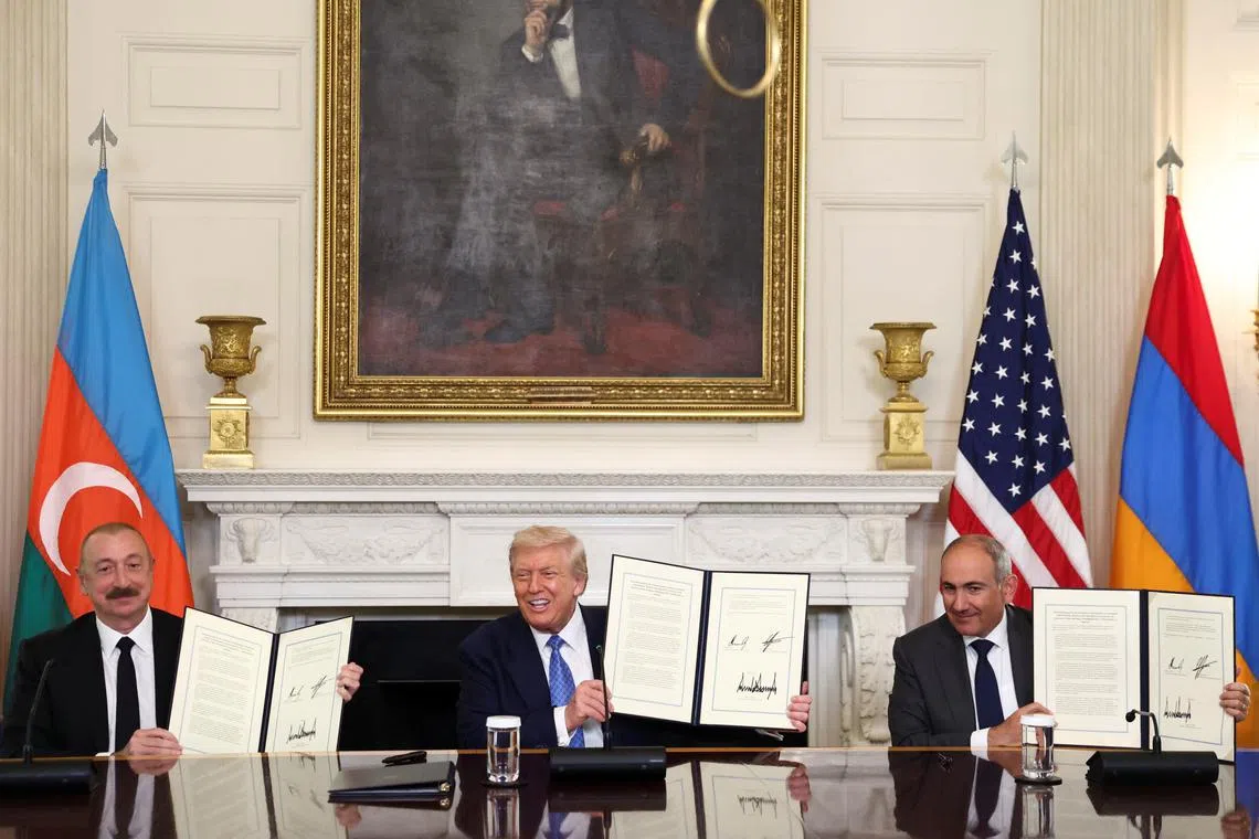 U.S. President Donald Trump, Azerbaijan's President Ilham Aliyev, and Armenia's Prime Minister Nikol Pashinyan pose with their documents during a trilateral signing event at the White House, in Washington, D.C., August 8, 2025. REUTERS/Kevin Lamarque/File Photo