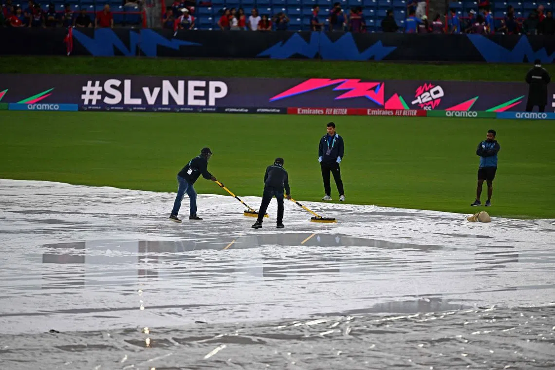 Match officials wiping water from the pitch as it rained ahead of the Twenty20 World Cup cricket match between Sri Lanka and Nepal at Central Broward Park & Broward County Stadium in Lauderhill, Florida on June 11, 2024.