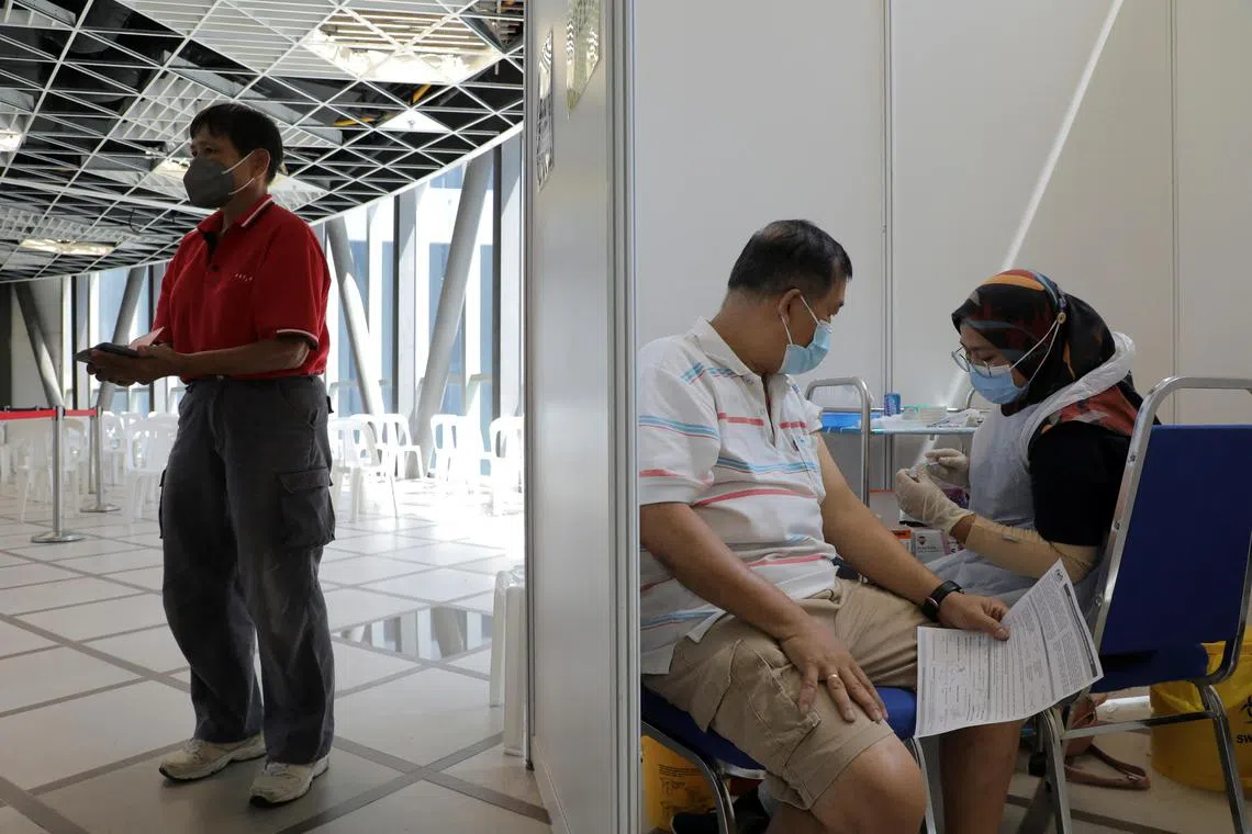 People wait to receive a booster dose of Pfizer's coronavirus disease (COVID-19) vaccine in Kuala Lumpur, Malaysia, January 5, 2022. REUTERS/Hasnoor Hussain NO RESALES. NO ARCHIVES
