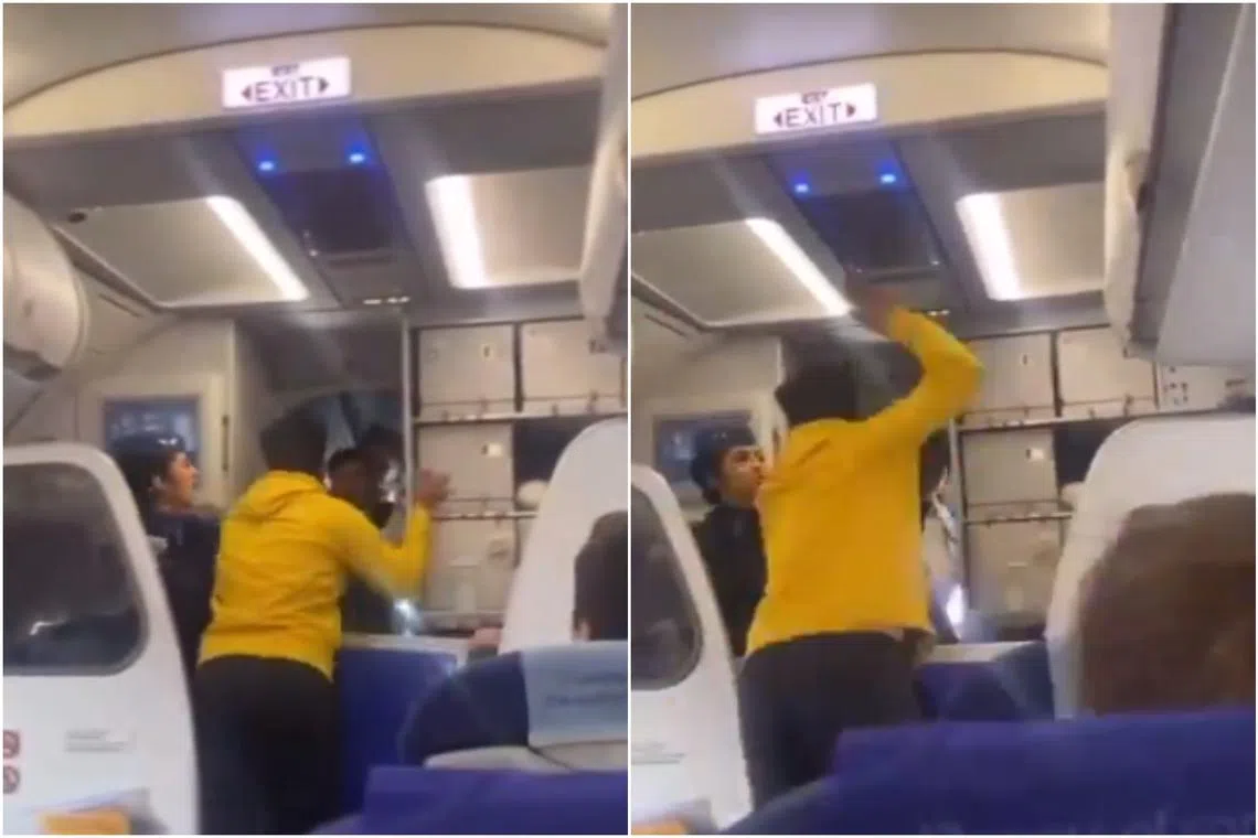 The passenger aggressively swings his arm and slaps the pilot, sending him backwards.