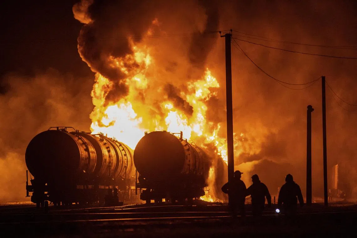 Residents watch tank cars set ablaze following recent shelling at a railway junction in the course of Russia-Ukraine conflict in Donetsk, Russian-controlled Ukraine, October 31, 2023. REUTERS/Stringer 