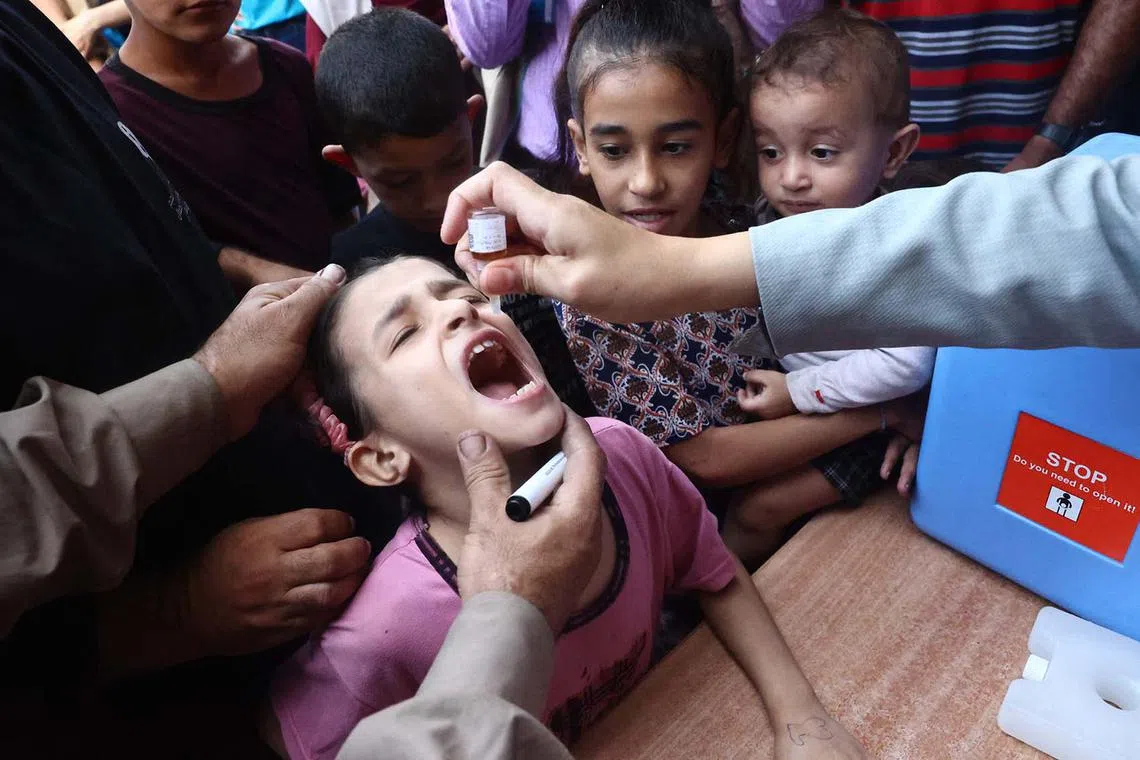 Palestinian children receiving drops as part of a polio vaccination campaign in Deir al-Balah in the central Gaza Strip on Oct 14, 2024, amid the ongoing war between Israel and Hamas. The campaign aims to fully vaccinate more than 640,000 children in the Gaza Strip.