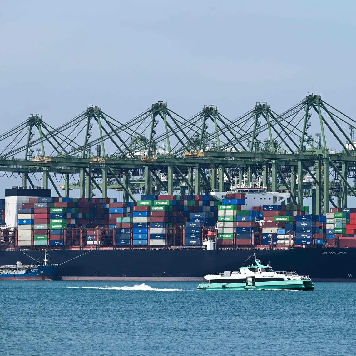 An oil tanker (L) refuels a container vessel docked at Pasir Panjang port terminal in Singapore on March 10, 2026. (Photo by Roslan RAHMAN / AFP)