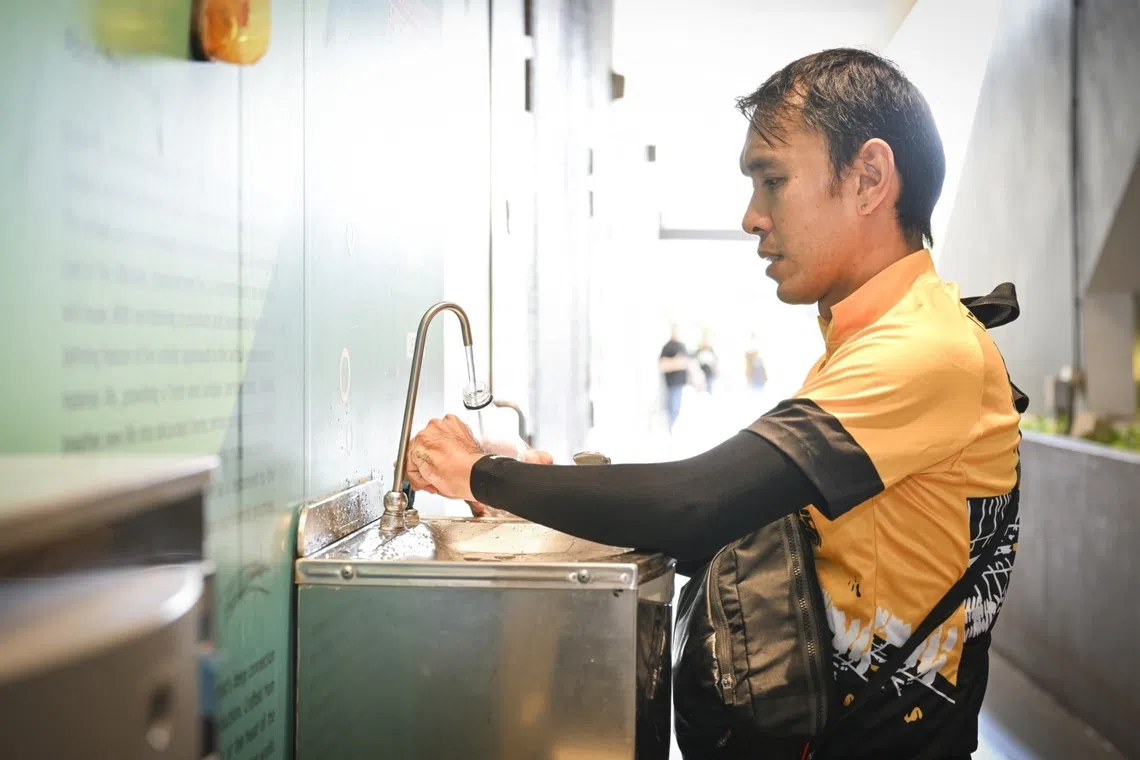 Delivery rider refills watter bottle at Our Tampines Hub