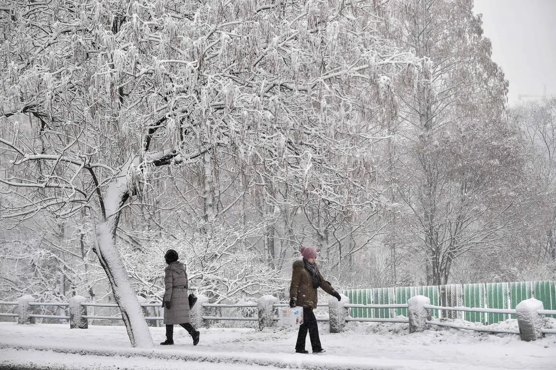 Pedestrians walking along a snow covered street in the Pothonggand District of Pyongyang, South Korea, on Jan 27, 2025.