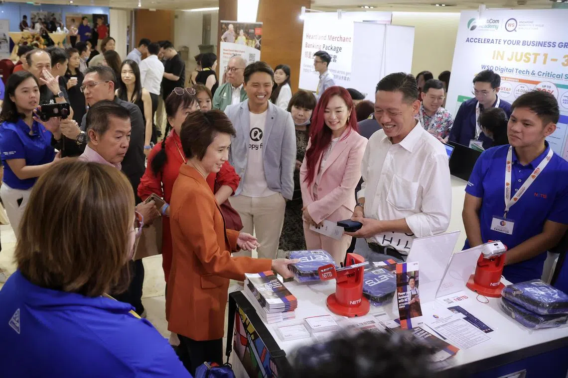 Ms Low Yen Ling, Minister of State, Ministry of Trade and Industry and Ministry of Culture, Community and Youth, accompanied by Ms Yvon Bock (in pink), founder and CEO of Hegen, and Mr Tan Jian Yong (in light blue), founder and CEO of Happy Fish Swim School, interacting with exhibitors at booths during the Singapore Heartland Enterprise Summit 2024 organised by the Federation of Merchants’ Associations at HDB Hub Auditorium on June 27, 2024. ST PHOTO: KEVIN LIM raheart