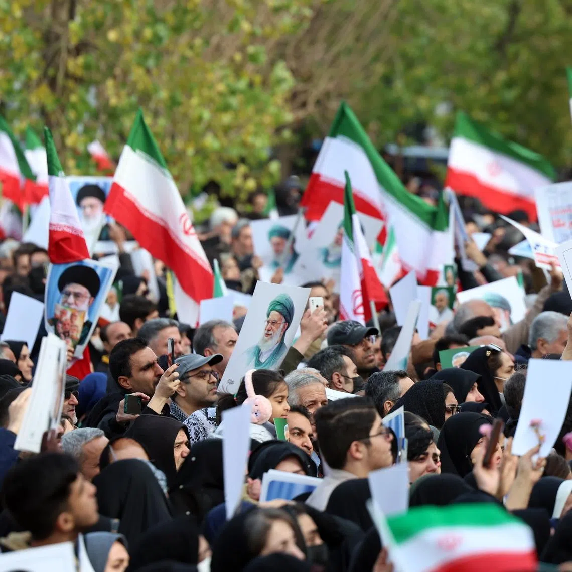 Mourners wave national flags and portraits of Iranian Supreme Leader Ayatollah Ali Khamenei during a funeral ceremony for security personnel killed during anti-government protests, in Tehran on Jan 14.