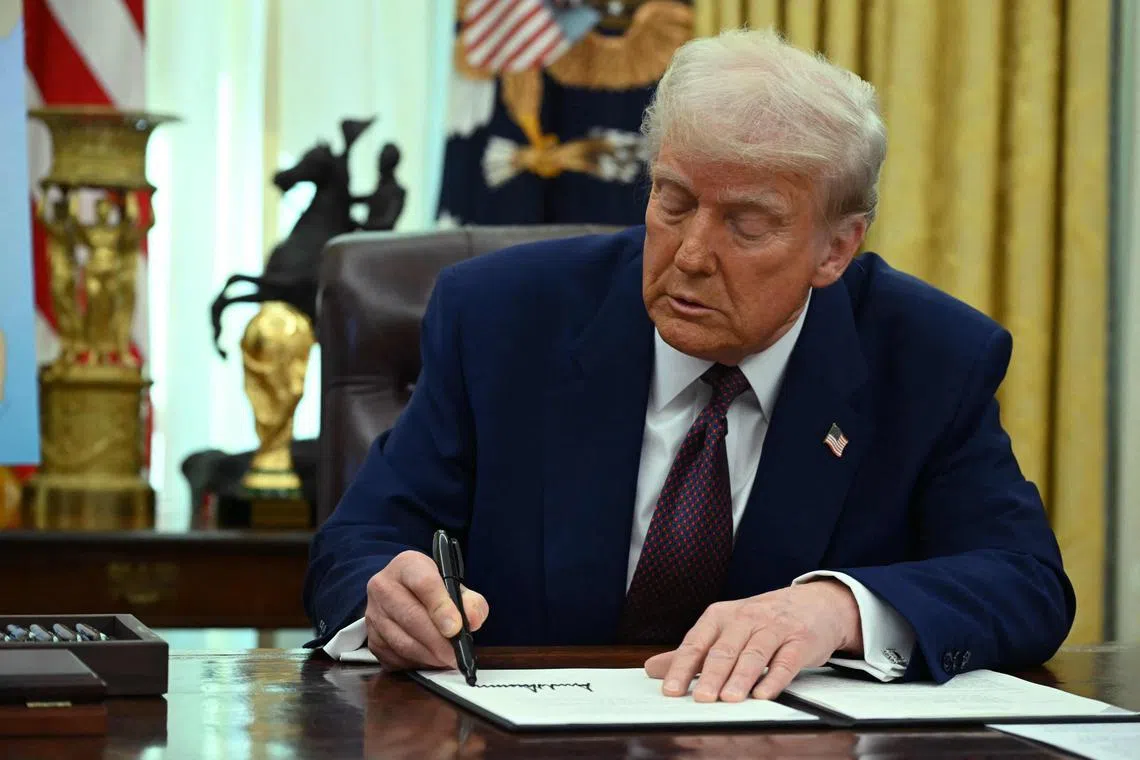 US President Donald Trump signs an Executive Order on reciprocal tariffs in the Oval Office of the White House in Washington, DC, on Feb 13, 2025. 