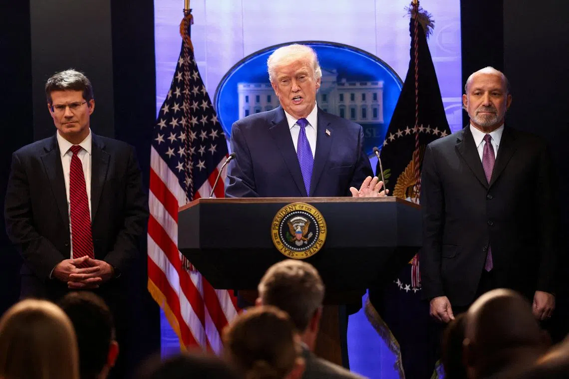 U.S. President Donald Trump, flanked by Secretary of Commerce Howard Lutnick and Solicitor General D. John Sauer, speaks during a press briefing at the White House, following the Supreme Court's ruling that Trump had exceeded his authority when he imposed tariffs, in Washington, D.C., U.S., February 20, 2026. REUTERS/Kevin Lamarque