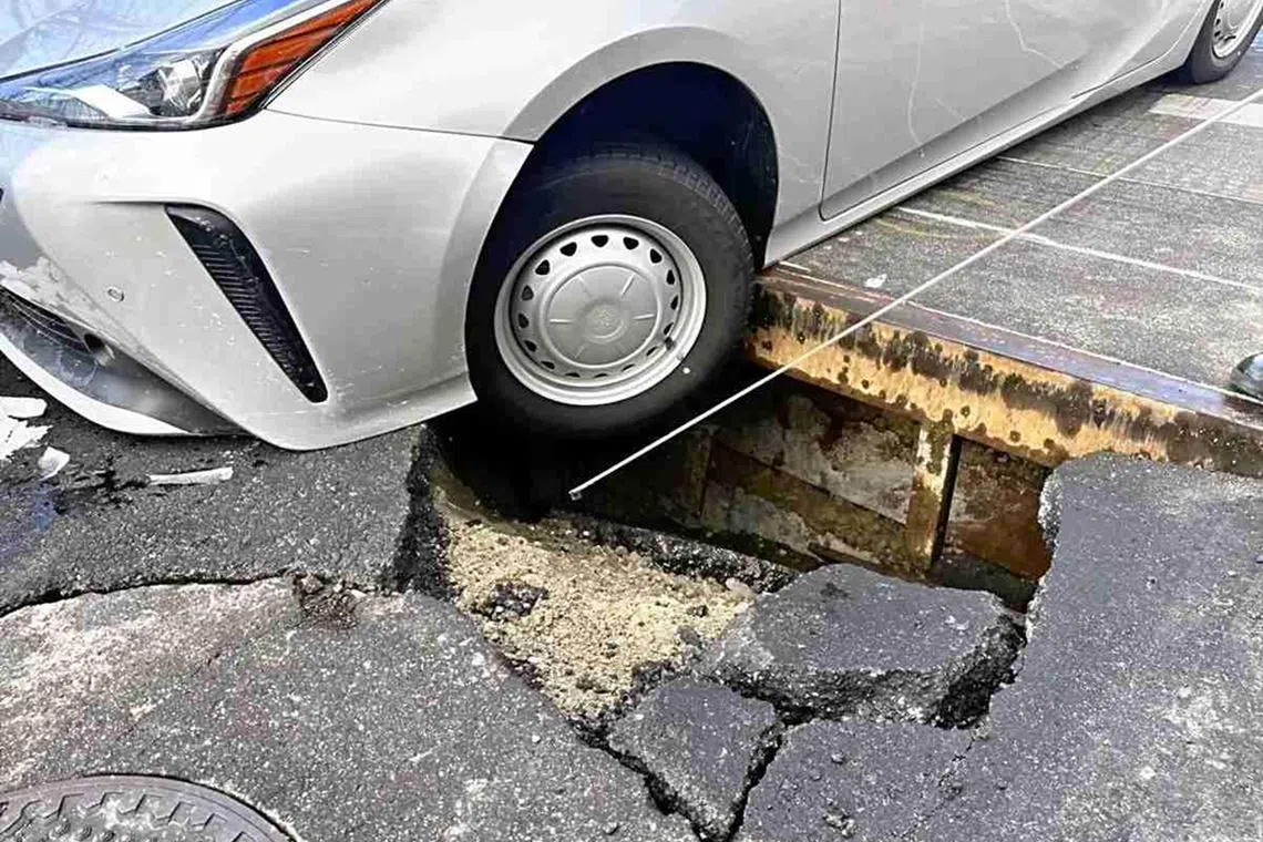 The left front tyre of the car got stuck in a cave-in n a road in the Japanese city of Nagoya.