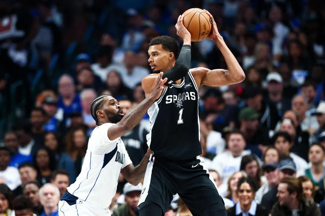 San Antonio Spurs forward Victor Wembanyama  looks to score as Dallas Mavericks forward Naji Marshall defends.