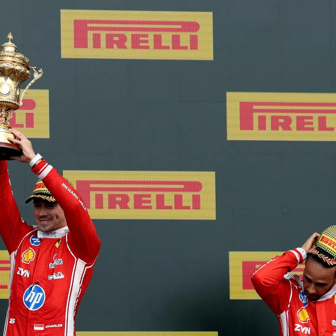 Formula One F1 - British Grand Prix - Silverstone Circuit, Silverstone, Britain - July 5, 2026 Ferrari's Charles Leclerc celebrates with his trophy on the podium after winning the British Grand Prix along with third placed Ferrari's Lewis Hamilton REUTERS/Andrew Boyers