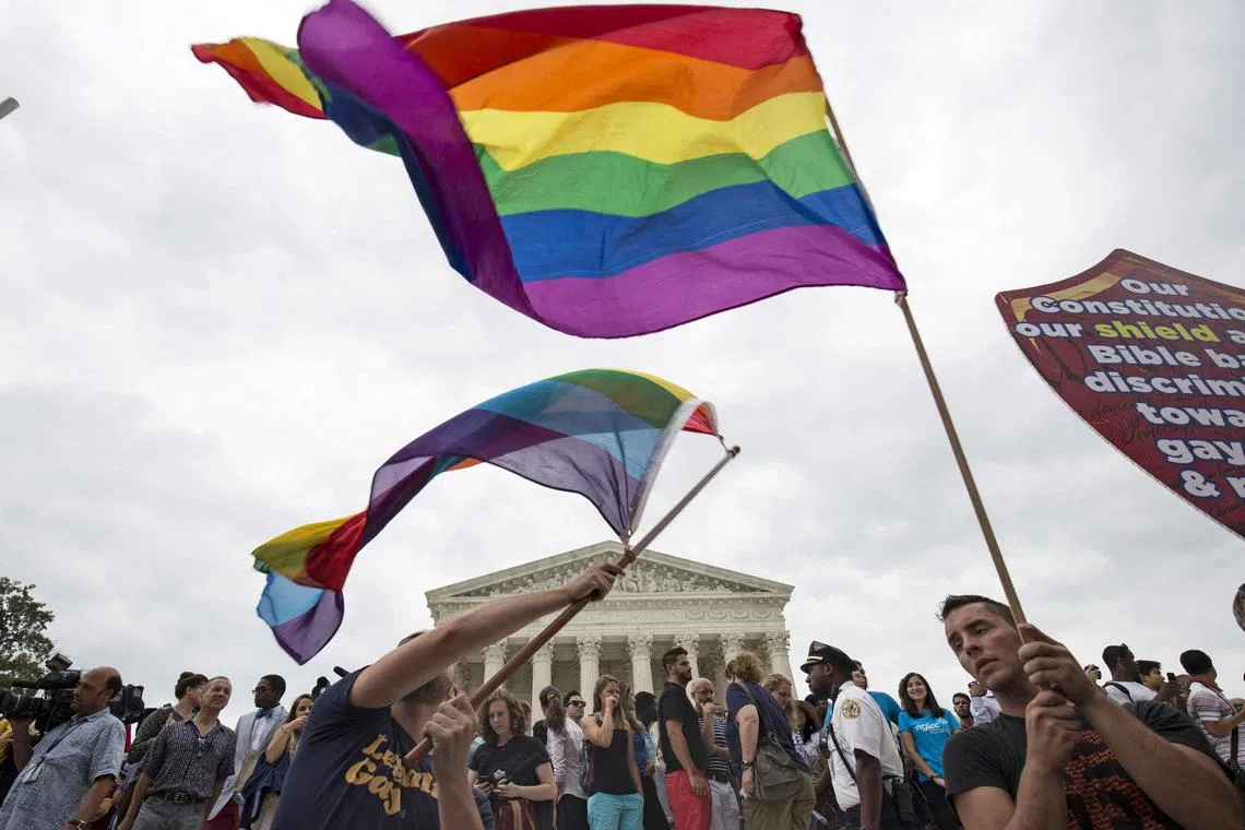 FILE PHOTO: Supporters of gay marriage wave the rainbow flag after the U.S. Supreme Court ruled that the U.S. Constitution provides same-sex couples the right to marry at the court building in Washington June 26, 2015. REUTERS/Joshua Roberts/File Photo