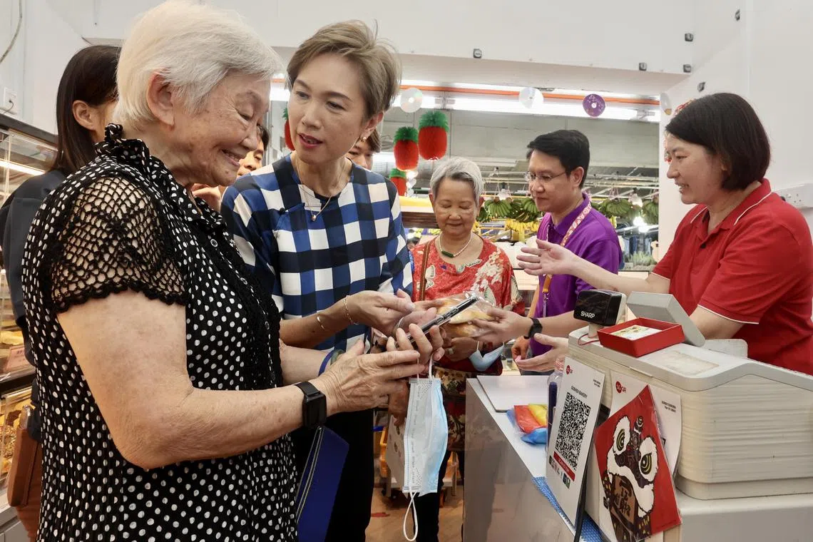 CMG20230219-WooFL01 /Josephine Teo's Engagement of Stakeholders on Digital Inclusion: E-Payment Learning Journey and Data for All Roadshow[Nee Soon East Seniors’ Hub, Next to Blk 293, Yishun Street 22] - Minister Teo talking to Mdm Koh Tong Cheng  (高冬青 81岁 退休人士）who used her digital platform to buy bread at the bread shop.